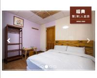 a bedroom with a bed with a wooden headboard at Jia Jia Homestay in Yuli