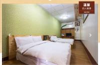 two beds in a room with green walls at Jia Jia Homestay in Yuli