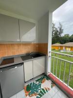 a kitchen with a sink and a balcony at Village Kawann - Toumalacai 246 in Grand-Bourg