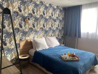 a bedroom with a bed with a tray of food on it at Contact Hôtel Foch in Besançon