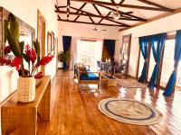 sala de estar con suelo de madera y cortinas azules en Casa Le Parc - Main Street, en Bocas Town