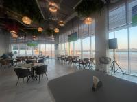 Un restaurante con mesas y sillas y grandes ventanales. en Yas Island - 2 Bedrooms, 2 toilet with shared Pool & Parking, en Abu Dabi