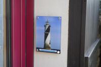 a sign on the side of a building with a lighthouse at Gîtes et Chambres - Les Buissonnets in La Turballe