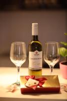 a bottle of wine and two wine glasses on a table at Apartman Dana in Nova Pazova