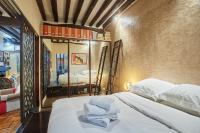 a bedroom with a bed with white sheets and a mirror at Apartment in heart of Marais by Studio prestige in Paris