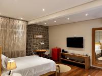 a hotel room with a bed and a television at Barra do Piuva Porto Hotel in Ilhabela
