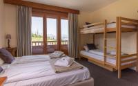 a bedroom with two bunk beds and a balcony at Hotel Le Chamois in L&#39;Alpe-d&#39;Huez