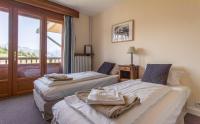 a hotel room with two beds and a balcony at Hotel Le Chamois in L&#39;Alpe-d&#39;Huez