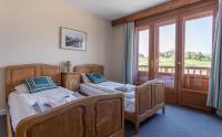 a bedroom with two beds and a balcony at Hotel Le Chamois in L&#39;Alpe-d&#39;Huez