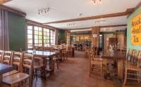 a restaurant with wooden tables and chairs in a room at Hotel Le Chamois in L&#39;Alpe-d&#39;Huez