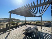 a bench on a wooden deck with a view of the beach at Apartment L&#39;Oustalet-3 by Interhome in Mimizan-Plage