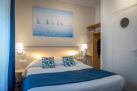Un dormitorio con una cama con dos almohadas azules. en Logis REX HOTEL Lorient, en Lorient