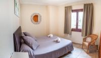 a bedroom with a bed and a chair and a window at Apartamentos Gravina in Tarifa