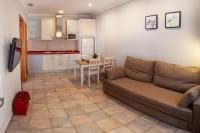 a living room with a couch and a kitchen at Apartamentos Gravina in Tarifa
