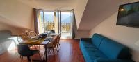 ein Wohnzimmer mit einem Tisch und einem blauen Sofa in der Unterkunft Chez Lulilo in Ax-les-Thermes