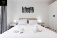 a bedroom with a white bed with two white pillows at Spacious, beautiful central penthouse with BBQ by 360 Estates in Tal-Pietà