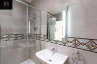 a bathroom with a sink and a shower and a mirror at Spacious, beautiful central penthouse with BBQ by 360 Estates in Tal-Pietà
