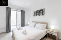 a white bedroom with a large white bed and a window at Spacious, beautiful central penthouse with BBQ by 360 Estates in Tal-Pietà