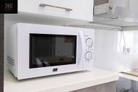 a microwave oven on a counter with a table in it at Spacious, beautiful central penthouse with BBQ by 360 Estates in Tal-Pietà