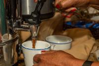 a person is pouring coffee into a cup at VOA Hotel Caxambu in Caxambu