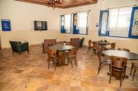 a room with tables and chairs and a flat screen tv at VOA Hotel Caxambu in Caxambu