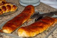 a tray with croissants and tongs on a table at VOA Hotel Caxambu in Caxambu