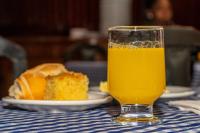 a glass of orange juice next to a plate of food at VOA Hotel Caxambu in Caxambu