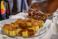 a person is serving food on a table at VOA Hotel Caxambu in Caxambu