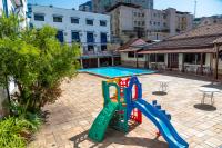 a playground in a courtyard with a swimming pool at VOA Hotel Caxambu in Caxambu