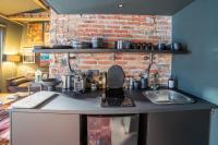 a kitchen with a sink and a brick wall at Place Vendôme Luxe 60 SQM Bail mobilité in Paris