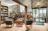 a library with chairs and a table and bookshelves at Hotell Linnéa - Helsingborg in Helsingborg