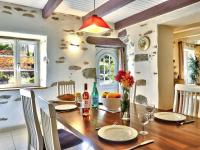 a dining room with a wooden table with chairs at Charming holiday home with garden in Huelgoat