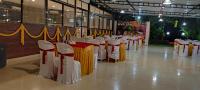 a row of tables with yellow and white table cloth at Mango Valley Resort Ganpatipule in Ratnagiri