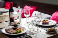 Una mesa con dos platos de comida y copas de vino. en Hotel Don Jaime 54, en Zaragoza