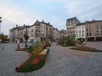 a city street with buildings and a park with a bench at Gîte Épinal, 4 pièces, 6 personnes - FR-1-589-82 in Épinal