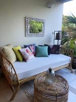 a wicker couch with colorful pillows on a porch at Maison de 3 chambres avec jardin clos et wifi a Saint Denis in Saint-Denis