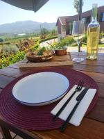 ein Tisch mit einem weißen Teller und einem Glas Wein in der Unterkunft Quinta da Corredoura, Hotel Rural in Guimarães