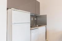 a kitchen with a white refrigerator and a sink at Les Narcisses - aux pieds des pistes in Saint-Léger-les-Mélèzes