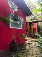 a red house with a potted plant in front of it at Hospedagem Recanto dos Ties in Abraão
