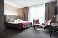 Un dormitorio con una cama y dos sillas y una mesa. en Best Western Hotell Ljungby, en Ljungby