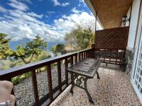 a porch with a bench on a balcony at Cingjing Vienna Pleasance Cottage in Ren&#39;ai