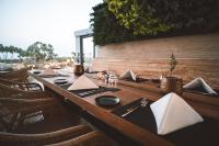 Una larga mesa de madera con platos y servilletas encima. en Periyiali Konnos Villas Beach Resort, en Protaras