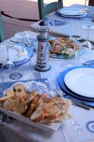 a table with a plate of bread and a lighthouse at Villaggio Camping Torre Del Porticciolo in Porto Conte