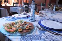 a table with a plate of food on a table at Villaggio Camping Torre Del Porticciolo in Porto Conte