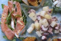 a plastic plate of food with salmon and potatoes at Villaggio Camping Torre Del Porticciolo in Porto Conte