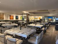 a dining room with white tables and chairs at Estela Barcelona in Sitges