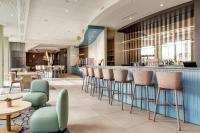 Un vestíbulo con un bar con sillas y mesas. en B&amp;B HOTEL Lille Lillenium Eurasanté, en Lille