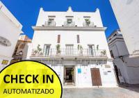 a white building with a sign that reads check in antigua at La Casa de la Favorita in Tarifa