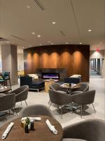 um átrio com cadeiras e mesas e uma lareira em Cambria Hotel Minneapolis Downtown em Minneapolis