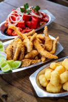 een tafel met borden vol eten en een bord friet bij Garça Branca in São Roque de Minas